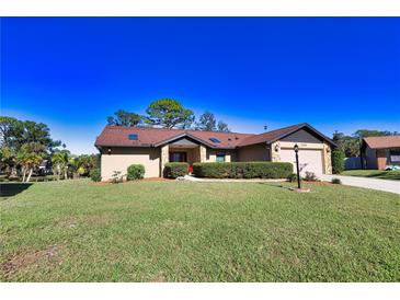 Charming single-story home with well-maintained lawn and stone accents, under a bright blue sky at 1206 Laurel Pines Cir, Nokomis, FL 34275