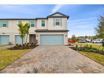 Two-story townhouse with light blue garage door and landscaping at 5406 Tripoli Dr, Palmetto, FL 34221