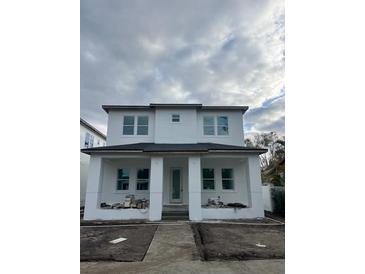 Two-story house with white exterior, dark gray roof, and landscaping at 820 46Th N Ave, St Petersburg, FL 33703