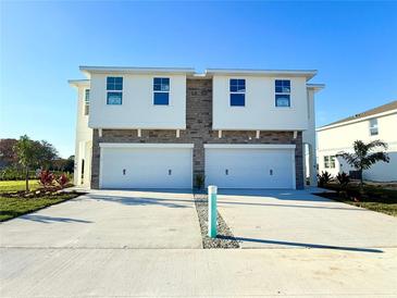 Two-story townhome with stone accents and two-car garage at 13719 Emerald Fields Dr, Hudson, FL 34667