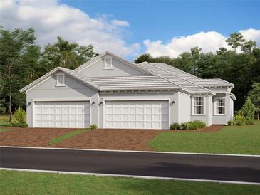 Two-car garage, light gray exterior, and a brown brick driveway at 18178 Cherished Loop, Bradenton, FL 34211