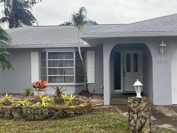 Gray house exterior with landscaped yard and stone accents at 2275 Pine View Cir, Sarasota, FL 34231