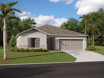 One-story home with attached garage, landscaping, and palm trees at 9836 Last Light Gln, Parrish, FL 34219