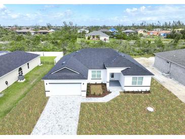 New construction home with gray paver driveway and landscaped yard at 9585 Calumet Blvd, Port Charlotte, FL 33981