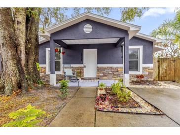 Cute gray house with stone accents, covered porch, and well-manicured landscaping at 1313 Louisiana St, Plant City, FL 33563