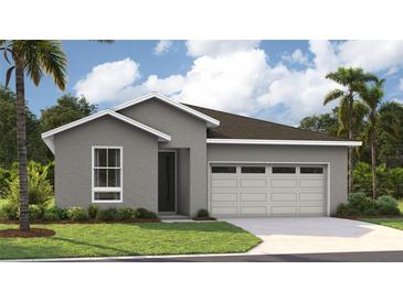 Single-story home with gray exterior, two-car garage, and landscaping at 9049 Players Dr, Weeki Wachee, FL 34613