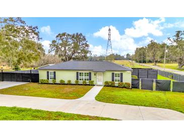 Charming single-story home featuring a well-manicured lawn, fresh exterior paint, and lush landscaping at 8600 W Knights Griffin Rd, Plant City, FL 33565