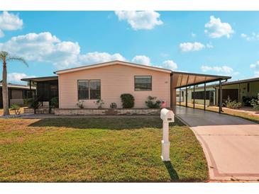 Charming single-story home with well-manicured lawn and covered carport at 313 Mariner Dr, North Port, FL 34287