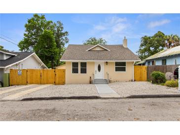 Updated bungalow with new paint, fenced yard, and a paved walkway at 8514 N Mitchell Ave, Tampa, FL 33604