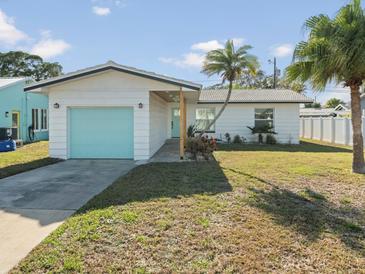 Charming single story home with light teal garage door and landscaped lawn at 15810 2Nd E St, Redington Beach, FL 33708