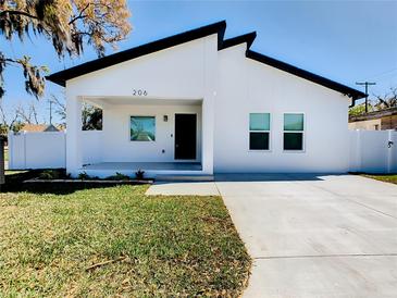 Modern white house with black accents, landscaped lawn, and driveway at 206 S Water St, Plant City, FL 33563