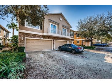 Townhouse exterior with two-car garage and a car parked in the driveway at 7001 Interbay Blvd # 336, Tampa, FL 33616