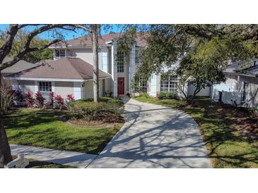 Two-story house with a red door and a large driveway at 9330 Hampshire Park Dr, Tampa, FL 33647