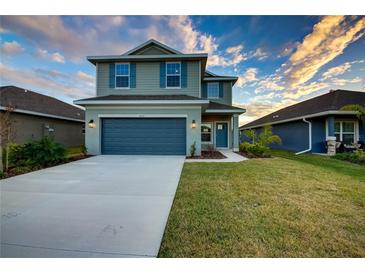 Two-story house with gray siding, blue door, and attached garage at 16111 69Th E Ln, Parrish, FL 34219