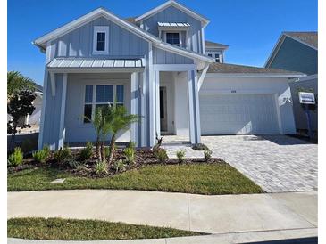 Two-story home with gray siding, landscaping, and a paved driveway at 1574 Running Tide Pl, Sarasota, FL 34240