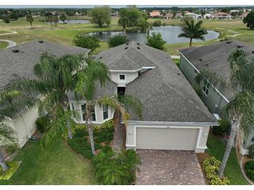 Aerial view of a house with a golf course and lake in the background at 1817 Pacific Dunes Dr, Sun City Center, FL 33573