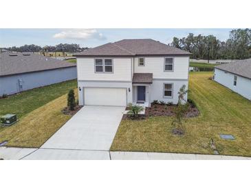 Two-story house with light-colored siding, a two-car garage, and a neatly landscaped yard at 12733 Wanderlust Pl, Parrish, FL 34219