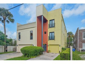 Modern three-story home with yellow and orange exterior and attached garage at 212 S Moody Ave # 2, Tampa, FL 33609