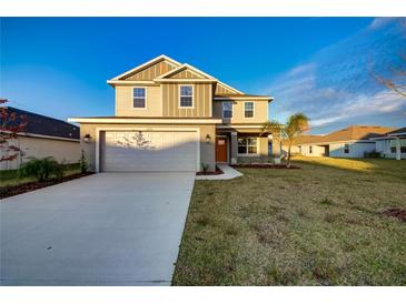 Two-story house with a gray exterior, white garage door, and a landscaped lawn at 16134 69Th Lane East, Parrish, FL 34219