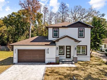 Two-story house with brown roof, white walls, and a brown door at 8119 N Dakota, Tampa, FL 33604