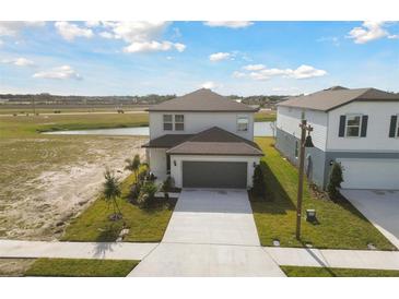 Two-story house with gray garage door and landscaping at 10627 Hidden Banks Gln, Parrish, FL 34219