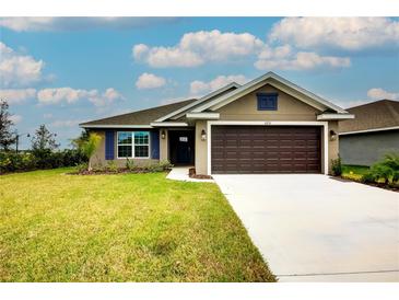House exterior featuring a two-car garage and landscaped lawn at 7014 162Nd Place E. E Pl, Parrish, FL 34219