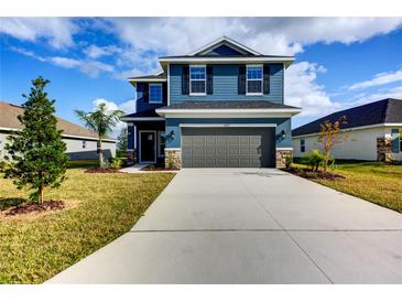 Two-story home with gray garage door and blue siding at 6822 162Nd E Pl, Parrish, FL 34219