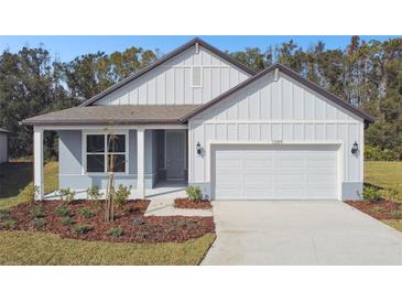 One-story house with gray siding, white trim, and a two-car garage at 1285 Kazaz Ct, Zephyrhills, FL 33540