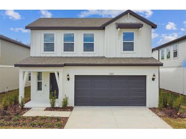 Two-story house with gray garage door and white accents at 1185 Kistna Dr, Zephyrhills, FL 33540