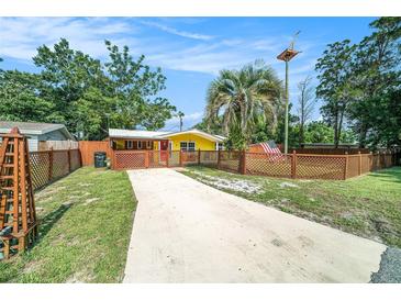 Cute yellow house with wood fence and driveway at 4045 Cranbrook Pl, New Port Richey, FL 34652