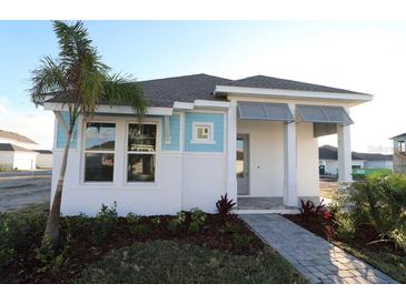 One-story home with light blue and white exterior, landscaped yard, and walkway at 7316 Donnybrook Ln, Sarasota, FL 34240