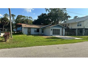 Cozy single-story home featuring a screen garage, and a well-maintained lawn at 6138 Island Dr, Weeki Wachee, FL 34607