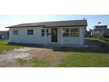 Charming one-story home featuring a neatly kept lawn and a freshly painted white facade at 3396 Minnow Creek Dr, Hernando Beach, FL 34607