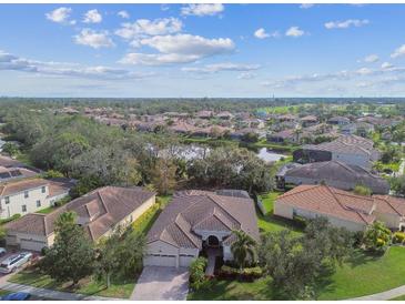 Aerial view of a residential neighborhood with lush landscaping and lake views at 5621 Rock Dove Dr, Sarasota, FL 34241