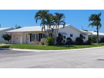 Charming single-story home with lush lawn, lovely palm trees, and white roof at 9870 36Th N Way # 4, Pinellas Park, FL 33782