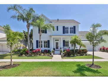 Two-story white house with blue shutters, landscaping, and a front porch at 415 Islebay Dr, Apollo Beach, FL 33572