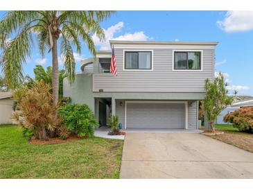 Gray two-story house with attached garage and palm trees at 1118 2Nd S Ave, Tierra Verde, FL 33715