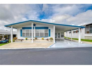 Landscaped yard with a white manufactured home and blue accents at 7141 El Matador St, Zephyrhills, FL 33541