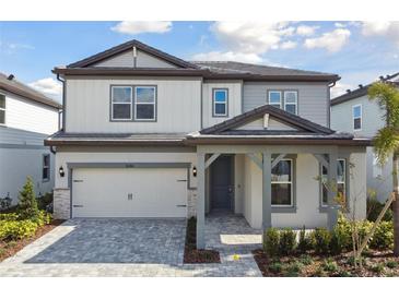 Two-story home with gray siding, stone accents, and a 2-car garage at 1686 Fallon Pass, Zephyrhills, FL 33541