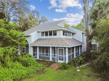 Two-story house with a screened porch and landscaped yard at 17307 Linda Vista Cir, Lutz, FL 33548