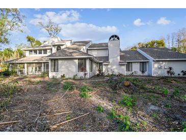 Two-story house with light gray siding, screened porch, and mature landscaping at 17307 Linda Vista Cir, Lutz, FL 33548