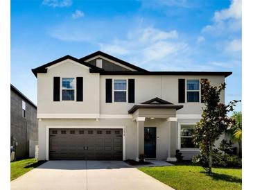 Two-story house with attached garage and landscaping at 12958 Wildflower Meadow Dr, Riverview, FL 33579