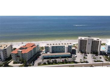 A high-angle view of beachfront condos, blue ocean, and a white sandy beach on a sunny day at 19440 Gulf Blvd # 201, Indian Shores, FL 33785