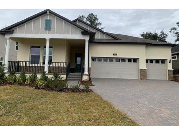 Two-story house with a three-car garage, front porch, and landscaped yard at 4638 Southern Valley Loop, Brooksville, FL 34601