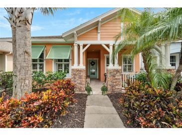 Charming house with peach walls, green shutters, and a stone walkway at 320 Winterside Dr, Apollo Beach, FL 33572