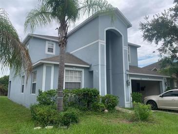 Two-story home featuring a stucco exterior, attached garage, and mature landscaping at 13034 Avalon Crest Ct, Riverview, FL 33579