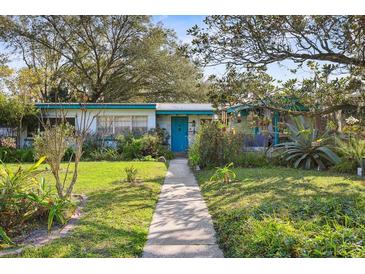 Ranch style home with teal accents, walkway, and mature landscaping at 509 Langford Cir, Plant City, FL 33563