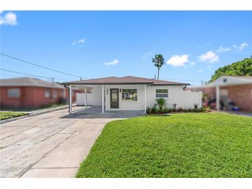 Newly renovated home with modern facade, landscaped lawn, and covered carport at 2906 W Braddock St, Tampa, FL 33607