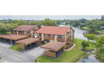 Aerial view of condo building with lake access and carport parking at 4027 Davit Dr, New Port Richey, FL 34652