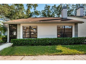 White exterior house with green landscaping and a brown roof at 3508 Magnolia Ridge Cir # 301, Palm Harbor, FL 34684